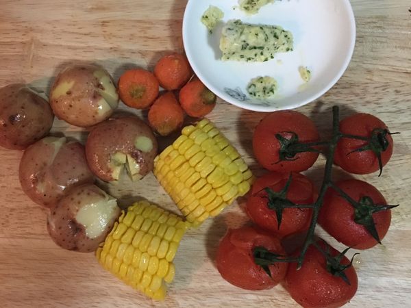 先準備配菜，小馬玲薯和小紅蘿蔔洗淨，煮滾ㄧ鍋水，放2-3匙鹽，將馬玲薯、玉米、小紅蘿蔔一起煮，小紅蘿煮約10分鐘即可先撈出。玉米煮熟也撈出備用，馬玲薯煮到鬆軟即可取出略微壓扁備用。