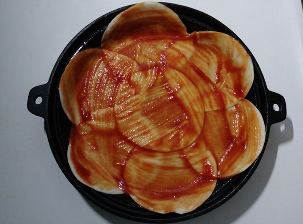 鐵烤盤先抹上一層薄薄的植物油，接著擺上水餃皮，重疊的部分可沾點水粘合，再用牙籤戳刺一些洞，最後均勻抹上一層番茄醬。