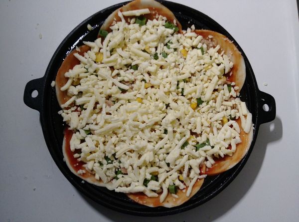 最後舖放披薩起司絲。送進已預熱１８０度Ｃ的烤箱中烘烤１５分鐘。