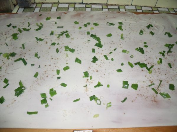 桌上抺油,擀開,抺油,撒蔥花。