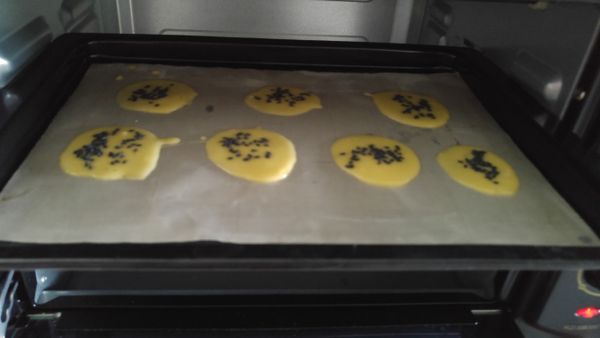 烤箱預熱，倒一匙麵糊至烤盤，利用湯匙背部將麵糊攤平，再麵糊上撒點芝麻。
進烤箱烘烤約1分鐘(上下火160度)，取出烤盤，利用薄餅半熟狀態將餅翻面再對折，最後再進烤箱烘烤約4~6分鐘即可。