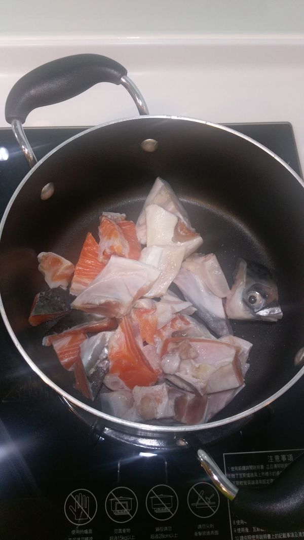 鮭魚洗淨後放入鍋中，加１/２鍋的水，熬煮鮭魚湯底，約１５分鐘