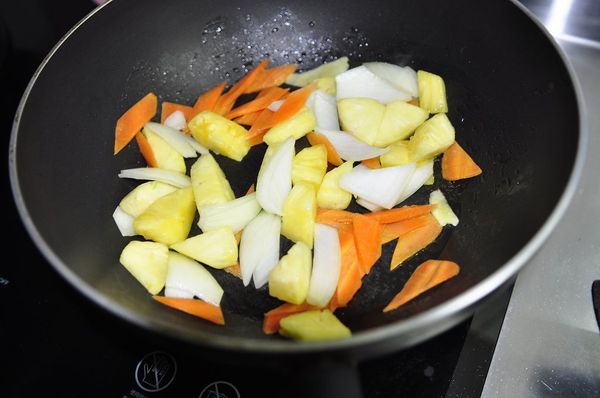 中火熱鍋 加一小匙油，薑片/洋蔥/胡蘿蔔/鳳梨拌炒，洋蔥稍軟再加蒜片拌炒