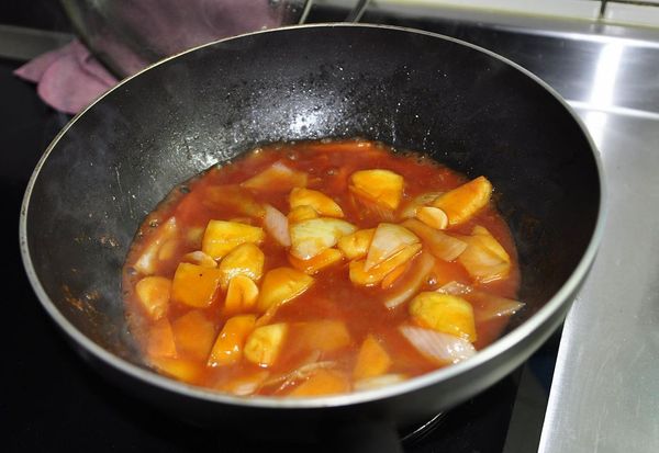 加入番茄醬/糖/拌炒，加入熱開水拌勻，轉中火煮滾後，用中小火煨煮約8分鐘，讓鳳梨的果香能融合在醬汁裡，邊煮邊拌才不會燒焦唷!