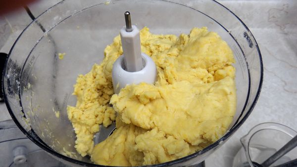 開始加入冰水(不要把冰塊放入喔!), 不要一次將所有的冰水加入, 需要一大匙一大匙的加, 再配合按壓攪打然後停的方式將材料混和成團. 每家麵粉的吸水性不同, 我約加了5大匙的冰水, 只要成團即可! (請自行斟酌)