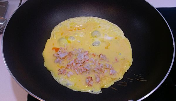 用剛才炒蝦的油鍋，熱鍋後，倒入蛋液，在蛋的半邊放上切碎的蝦仁。保持中小火，等蛋底層煎到凝固後(表層仍濕潤)，將蛋往蝦仁這邊對折過來，再稍微煎一下確定蛋不會散開，即可起鍋！