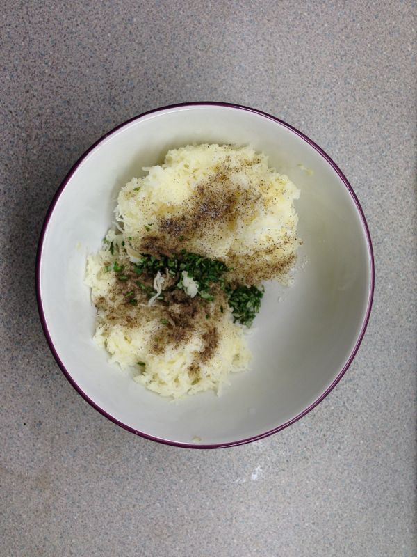 等馬鈴薯冷卻後，剝皮刨成絲，加入調味料：鹽、黑胡椒、迷迭香。拌勻