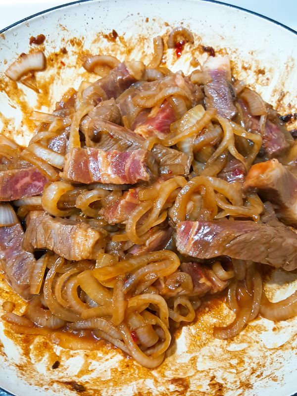 再加入牛肉條翻炒到牛肉條四面都熟了