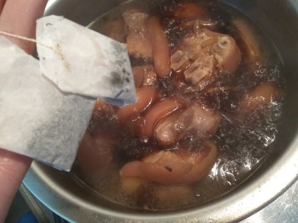 熄火前放入2包紅茶包，這個動作可以讓豬腳嘗來有紅茶的香氣，且豬皮不油膩。因為紅茶不能明火煮，不然滷汁會變得澀味，可以燜個10分鐘就可以取出紅茶包。