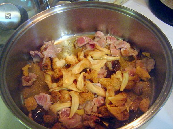 2. 依序再加入梅花肉片及浸泡好的猴頭菇, 淋上米酒拌炒一下即可