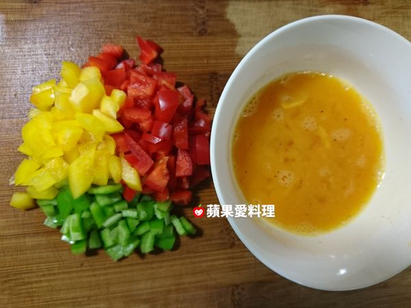 將青椒和剩下的紅椒、黃椒切丁。蛋打成蛋液，加入黑胡椒、白胡椒、味醂和鹽拌勻。