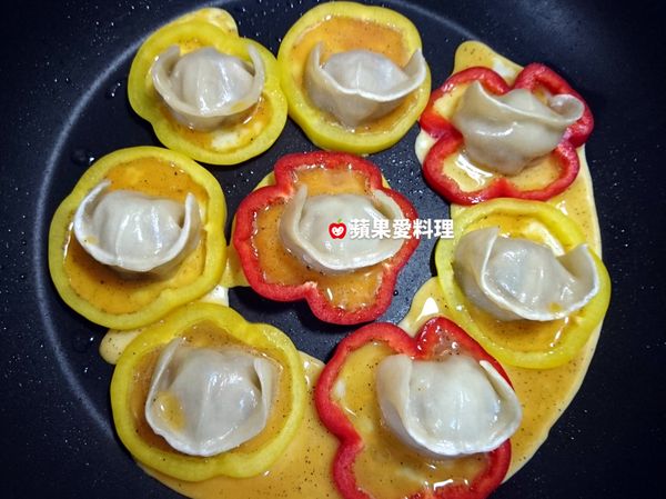 將蛋液倒入甜椒圈裡，蓋鍋蓋慢煎。