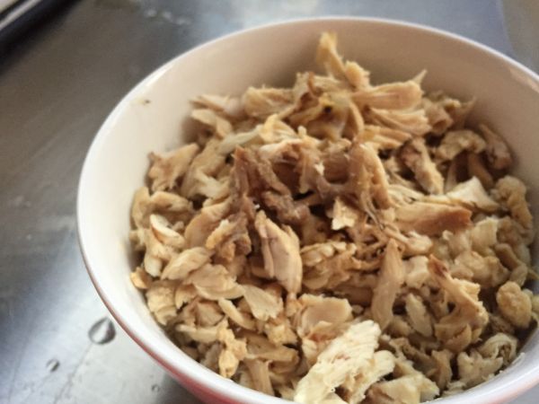 高湯熬煮完成後，將雞骨上的肉撥下來，撥成細絲當作雞蓉。