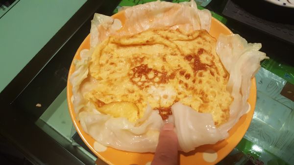 取一盤子，放上高麗菜，再放上蛋皮，將梗壓入，卷起。