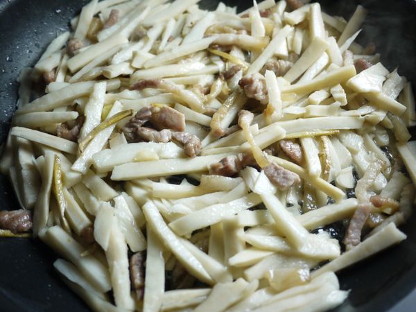 下筍絲拌炒均勻。
沿鍋邊嗆入醬油,再加入糖翻炒。