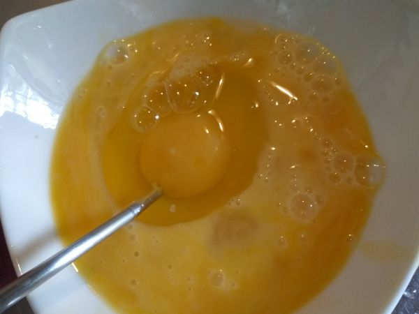 在煮水的時候，在碗裡打入3顆雞蛋，並用湯匙拌勻。