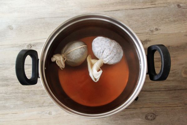 將3000cc水煮沸，決明子與麥茶裝入布袋中後放入鍋中，續煮5分鐘後關火。