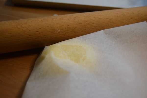 取一小塊麵團，夾放在烘焙紙中，桿約0.6公分厚