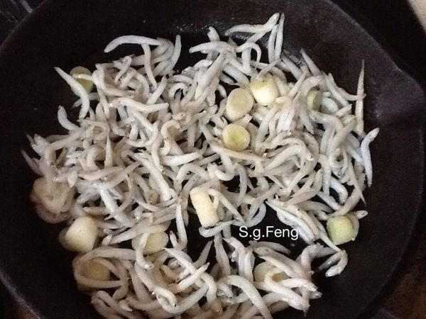 5.放入蔥白及吻仔魚，拌炒乾燥至有香氣(去除水份)，再加入1大匙的麻油。