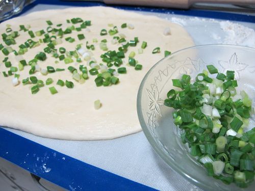 讓蔥花平均的散落在麵糰上。