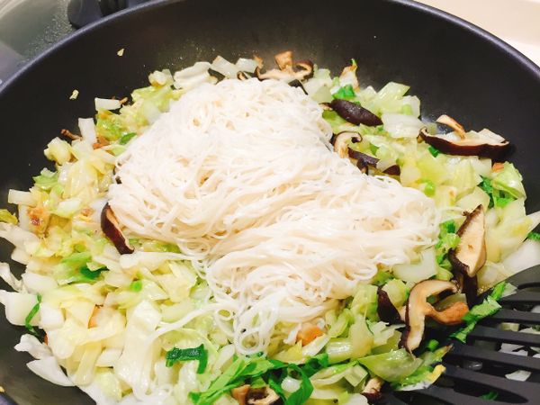 將麵線置入方才炒好的青蔬配料拌炒