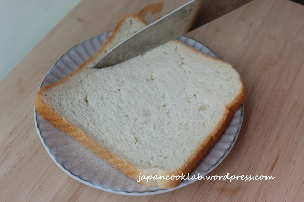 在白面包上切入一個方向的斜線, 然後再反方向切入斜線。