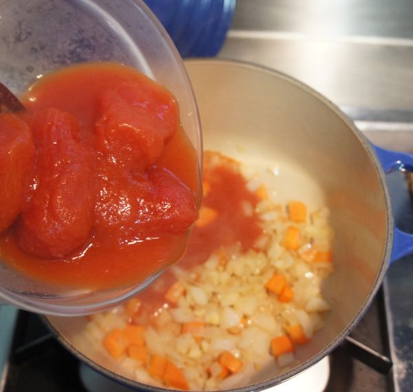 放入蕃茄，攪拌均勻後，蓋鍋以小火悶煮約半小時。