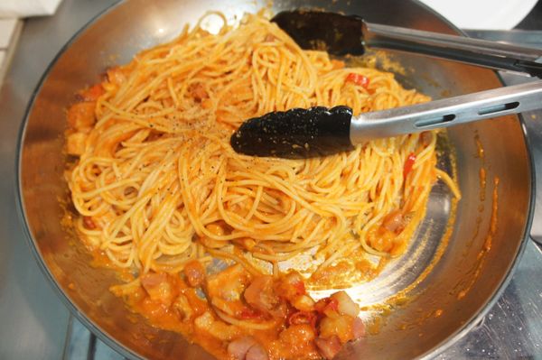 放入紅醬，稍微攪拌後，再放入瀝乾水分的麵條攪拌均勻，並以鹽、黑胡椒調味。