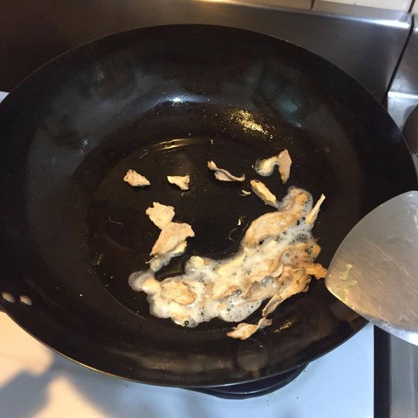 熱鍋後加入苦茶油，再爆香竹薑片，再把雞肉放進去煎