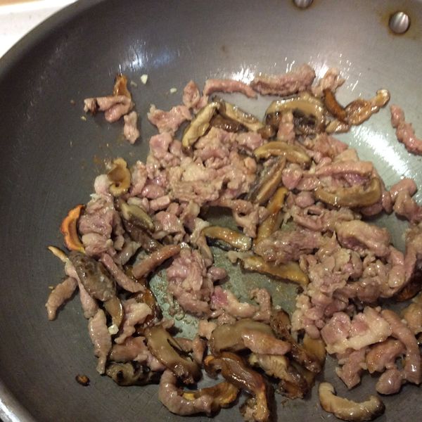 另起煱，煱熱下二湯匙油，下冬菇絲及肉絲爆炒至肉熟。
