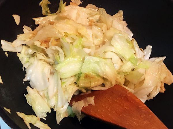 加入蒜片，香氣稍微出現後，即刻放入高麗菜。
稍微炒軟後，加上雞粉、麻辣油