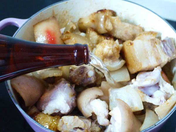 之後倒入醬油炒香，再加入米酒至豬肉約8~9分滿