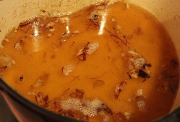 將雞高湯和白酒倒入鍋內，煮至滾起。再放入番紅花。