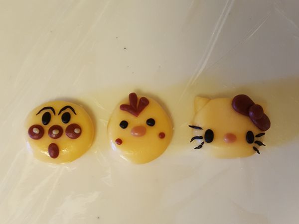 預留一小部分麵團染色，剩餘麵團取約8g-10g麵團搓圓，再用染色的麵團像搓黏土一樣做出五官表情貼合