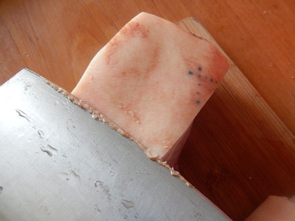 首先將買來的豬五花肉再仔細的用刀刮除皮上頭的雜質。