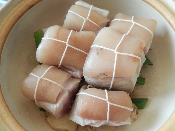 將處理好的豬肉切成正方塊，之後用棉繩像捆禮物般把肉捆起來。