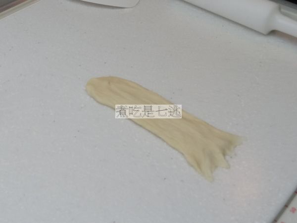 麵糰放在桌面上，光滑面向下，尾端掰薄絲狀，讓麵糰黏在桌面上