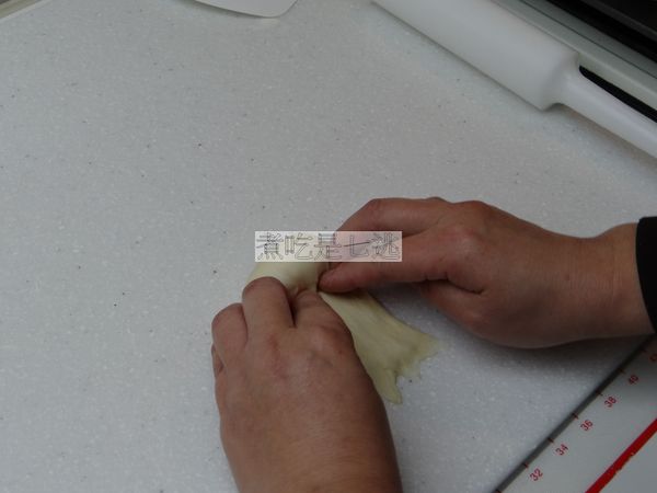 先向身體這方向摺一折然後左、右手並排，用指腹將兩邊摺成倒V字，然後麵糰往身體方向一邊捲一邊兩邊往麵糰內推壓，不要壓中間，中間要保持胖胖圓圓的