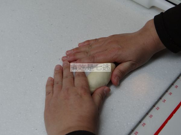 用雙手虎口圍住麵糰兩側，整成橄欖狀，最後收口向上，用手指將收口捏緊收口朝下後，將麵糰兩側整好