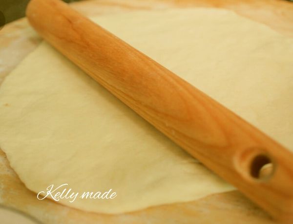 把麵團從麵包機中倒出，這個麵糰是比較濕黏會沾手的狀態，桌上要先撒點高筋麵粉，手上也要避免沾黏，將麵團用桿麵棍壓出空氣後，略桿成長橢圓形。