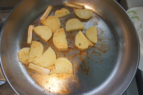 若鍋中已無餘油，可再下少許油熱鍋，並下蔥白、馬鈴薯，煎至兩面微焦。