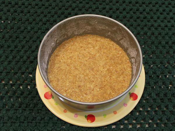 將融化的奶油加入餅乾屑中搓揉均勻, 再加壓至烤模底部, 確實壓合緊密, 移到冰箱冷藏30分