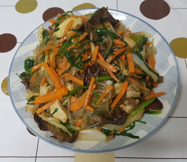 這時在鍋內加入一點芝麻油下去炒一下冬粉，之後再將剛已經炒好的青菜及肉絲也都放下去，再將醬油給加進去炒，炒得差不多就可以關火準備上菜，上菜之前在雜菜上灑上芝麻粒就大功告成了。