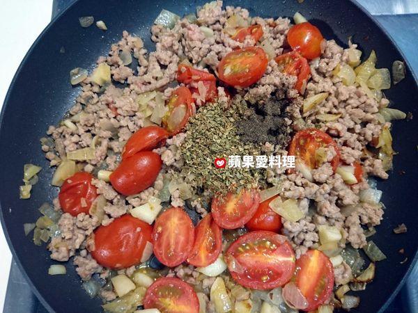 肉炒到變白色時，灑入義大利香料和黑胡椒，拌炒。