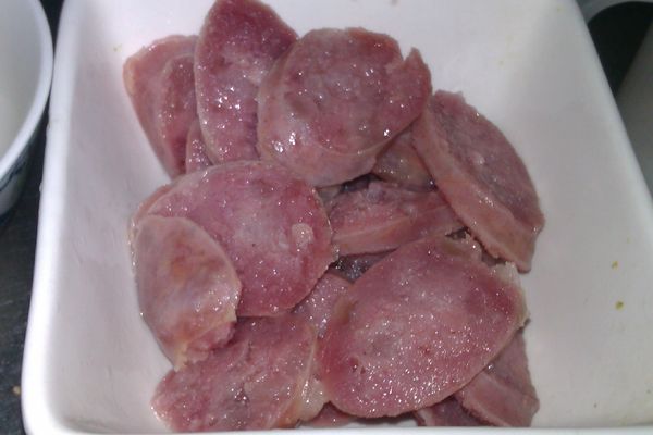 先將香腸放入電鍋蒸熟，再切成薄片