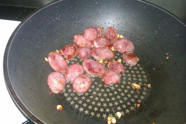用蒜末爆香後，放入香腸將兩面煎的焦香