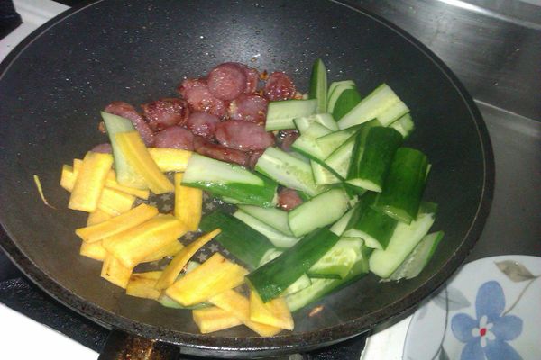 再將胡蘿蔔切絲與小黃瓜切薄片全下鍋一起拌炒