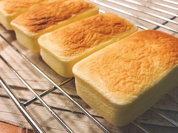 烤箱預熱180~190度，將烤模置於加入1cm常溫開水的烤盤，烘烤10分鐘，再降溫至130度烘焙60分鐘，至蛋糕表面呈金黃色(蛋糕邊緣和烤模分離即是蛋糕已烤熟)。