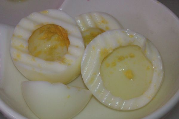 將煮熟雞蛋由尖頭部分切開，留下3顆，將蛋黃挖清，蛋黃與另外兩顆雞蛋切碎後放入沙拉盆中