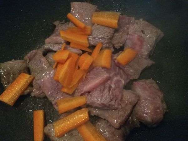 紅蘿蔔削去外皮，切薄片，放入鍋中一起拌炒。